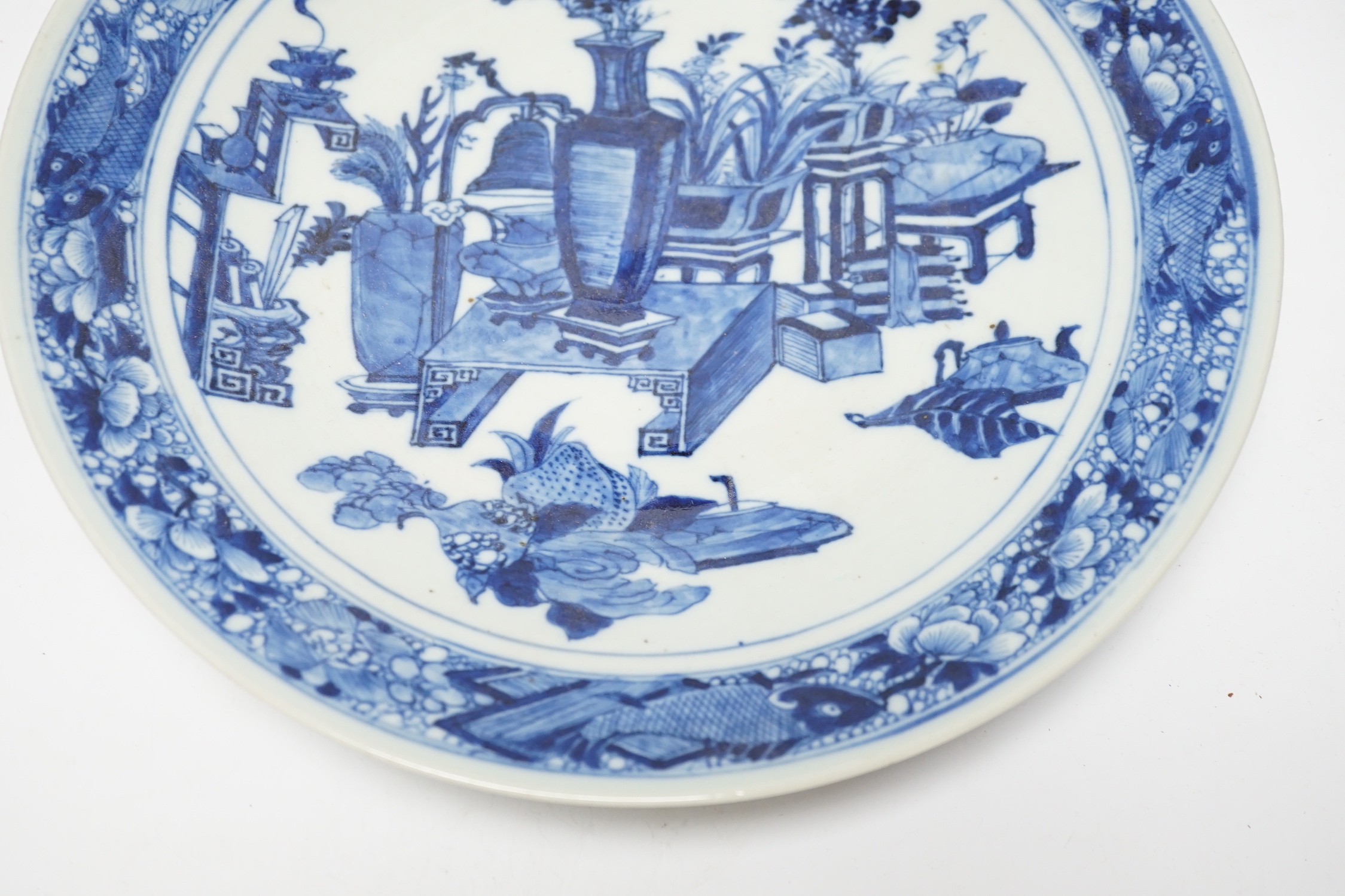 A 19th century Chinese blue and white ‘Hundred Antiques’ dish, with fish to the border, 30cm in diameter